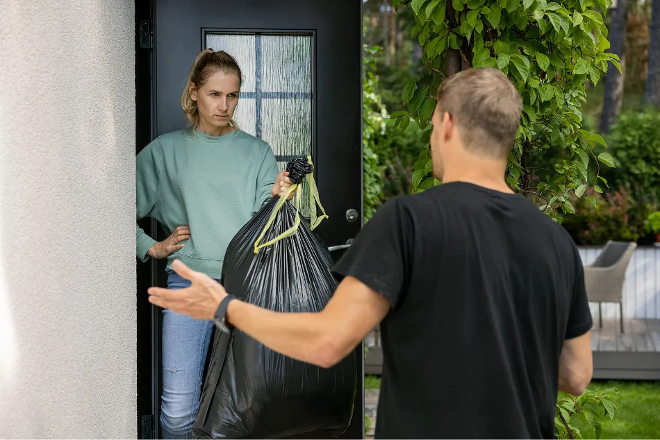 Photo of a woman kicking a man out of the house